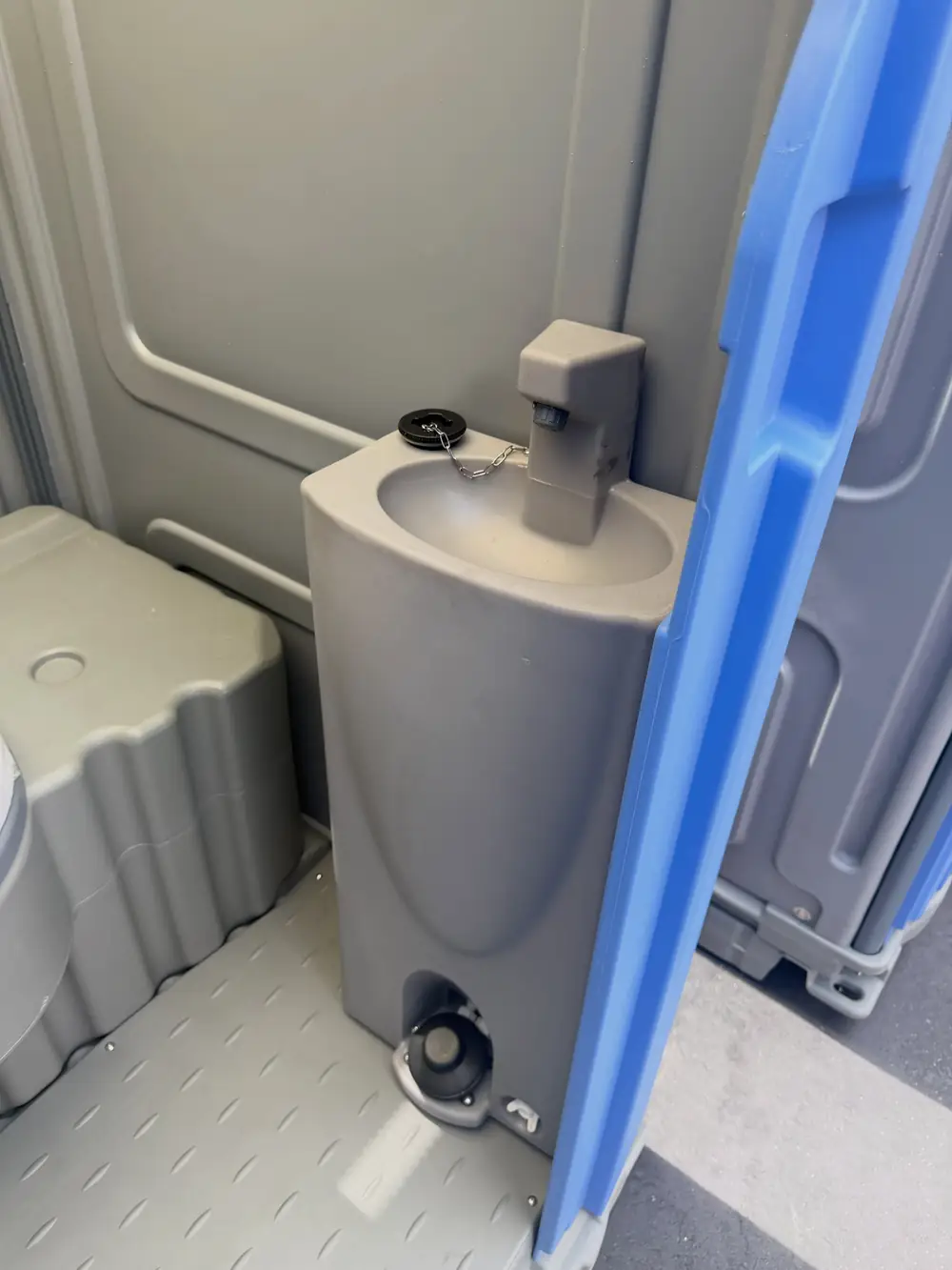 Foot-pump sink built into a portable toilet